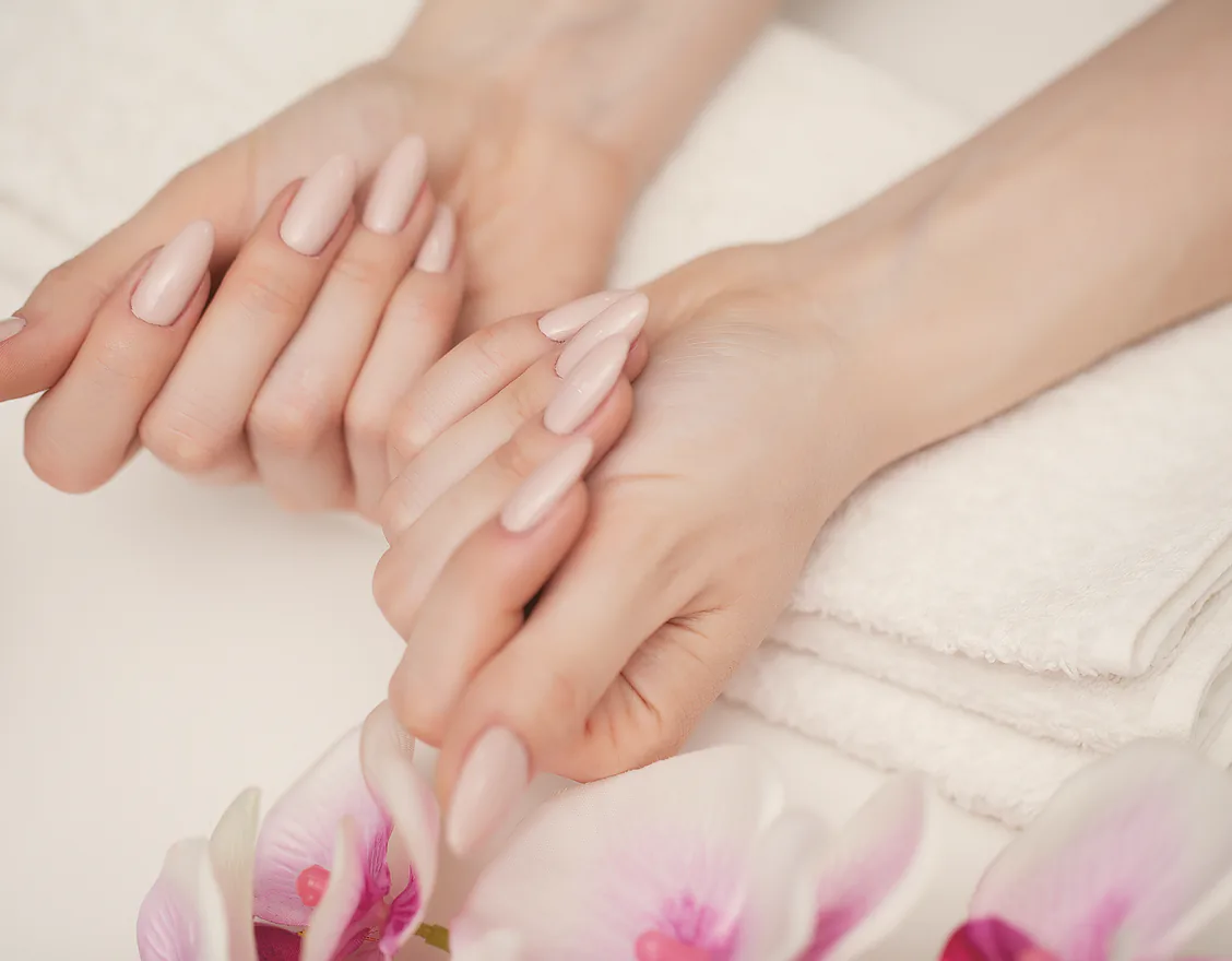 A freshly finished manicure, hands resting on a towel