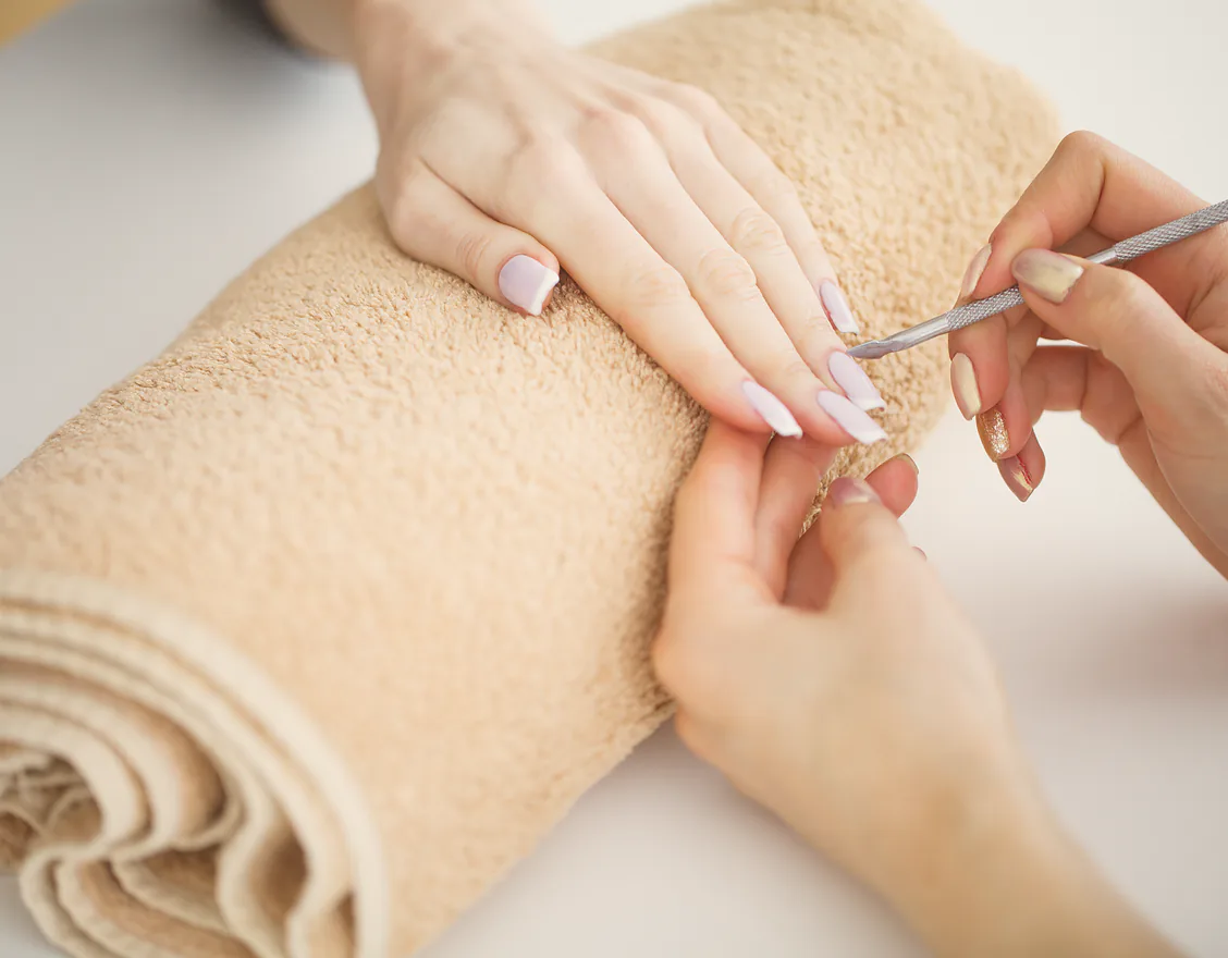 A client’s hand resting on a towel while the cuticles are worked on
